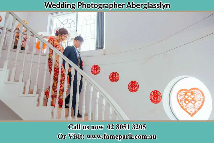 Photo of the Bride and the Groom walking down the stairs Aberglasslyn