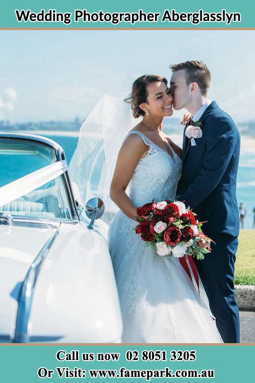 Photo of the Groom kissing his Bride outside the car Aberglasslyn NSW 2320