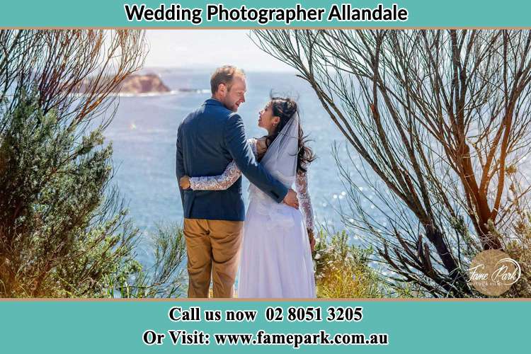 Photo of the Groom and the Bride looking and holding each other at the romantic sea front view Allandale NSW 2320