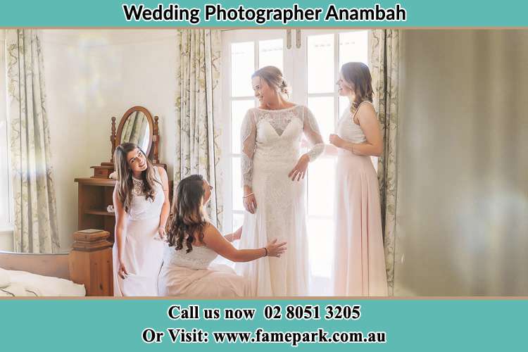 Photo of the Bride assisting by her bridesmaids to fit her wedding gown Anambah NSW 2320