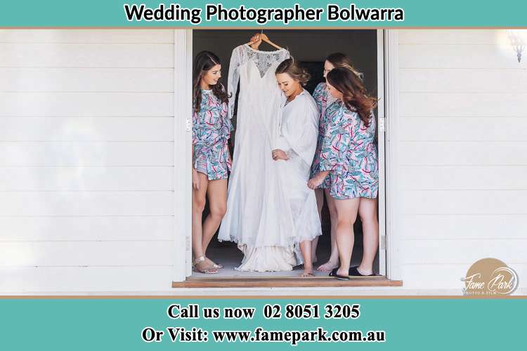 Photo of the Bride on the door with her bridesmaids checking her wedding gown Bolwarra NSW 2326