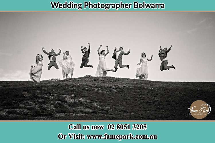 Cinematic photo of the Groom and the Bride together with the groom men and bridesmaids jumping Bolwarra NSW 2326