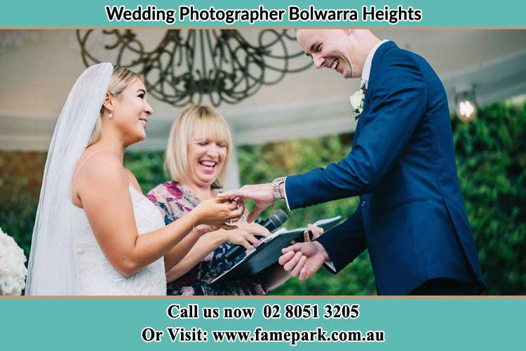 The Groom and the Bride holding their hands while the pastoress is watching Bolwarra Heights