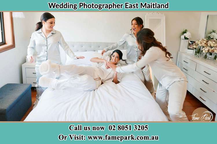 Photo of the Bride playing with her bridesmaids on the bed East Maitland NSW 2323