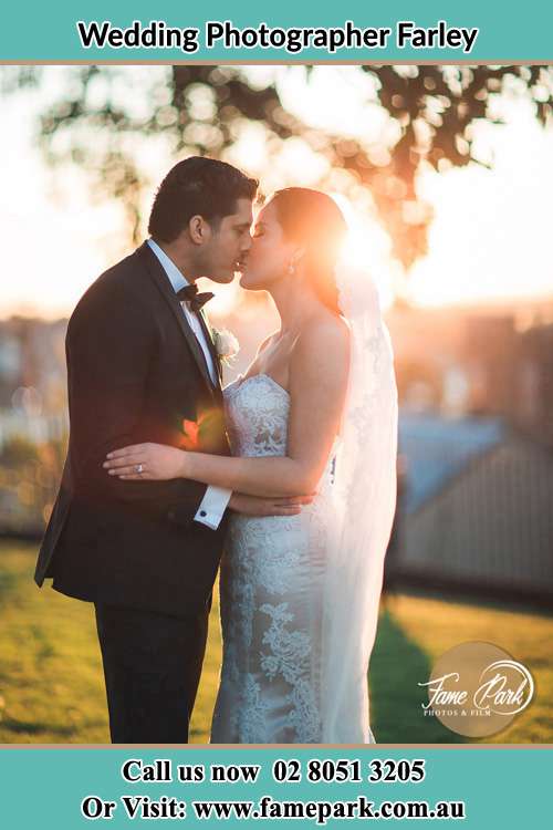 The Groom and the Bride Kissing before a sunset Farley