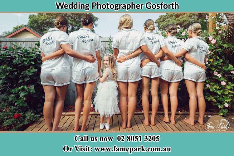 Behind photo of the Bride and the bridesmaids with the flower girl looking back the camera Gosforth NSW 2320