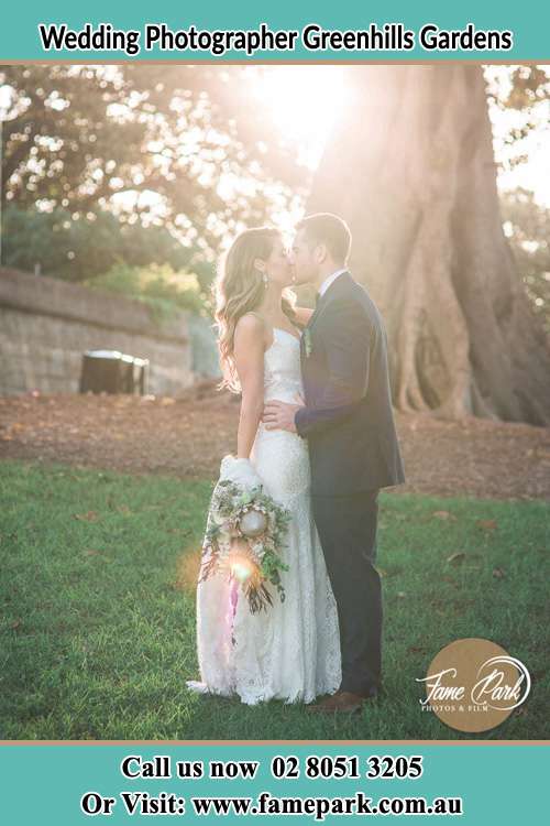 Photo of the Groom and Bride kissing near the big tree Greenhills Gardens