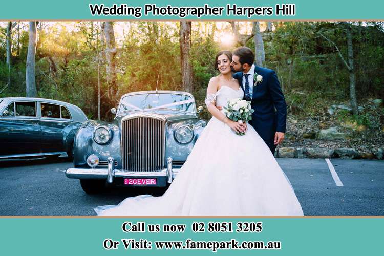 Photo of the Groom kissing her Bride at the front of the car Harpers Hill NSW 2321