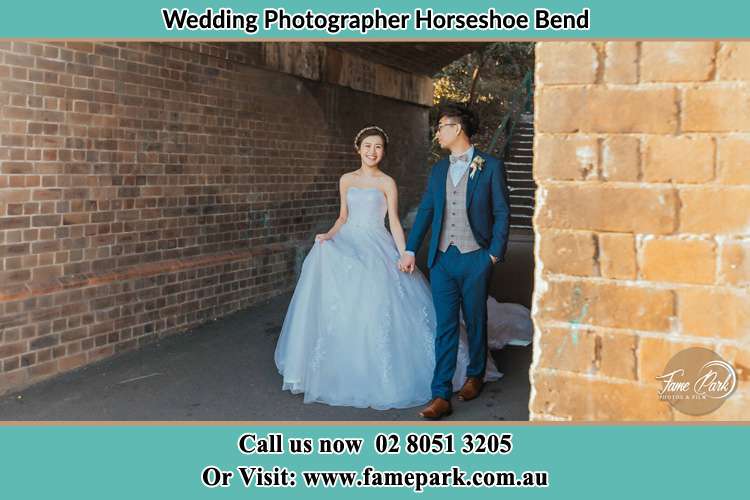 Photo of the Groom and the Bride walks while holding their hands Horseshoe Bend