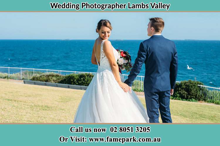 Photo of the Bride looking at her back as the Groom hold her hands Lambs Valley