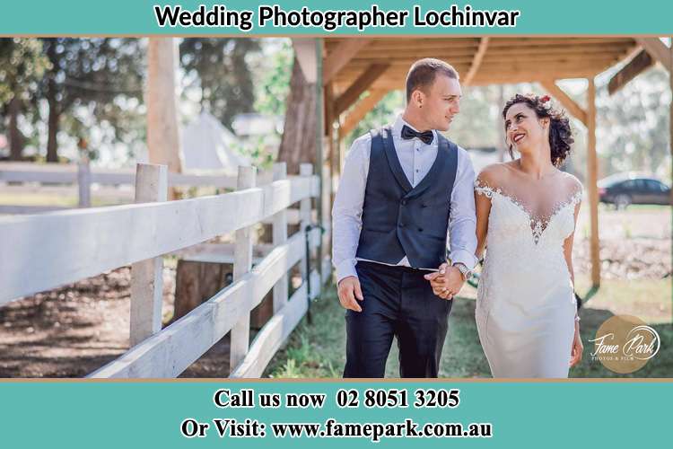 Photo of the Groom and the Bride holding their hands while walking Lochinvar