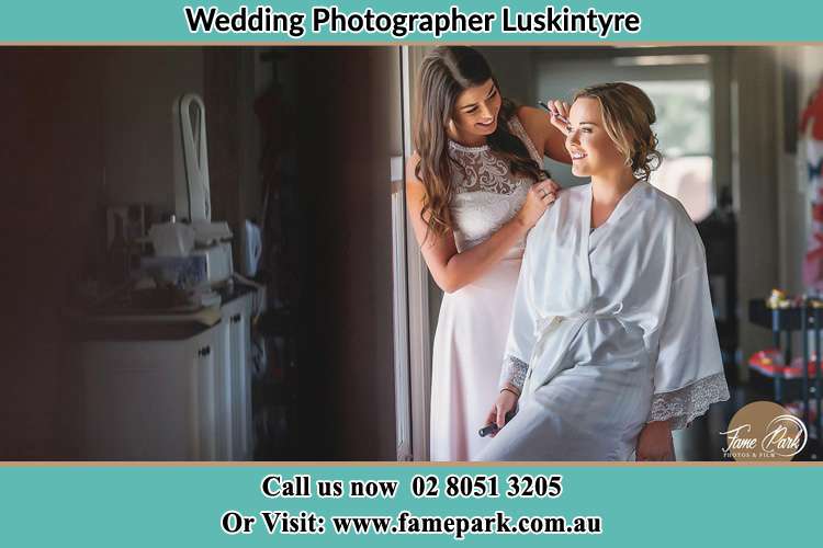 Photo of bridesmaid preparing the Bride for her wedding Luskintyre