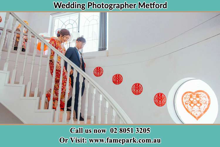 Photo of the Bride and the Groom walking down the stairs Metford