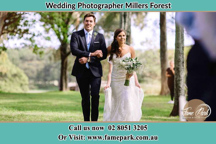 Photo of the Bride and the Groom walking in the yard Millers Forest