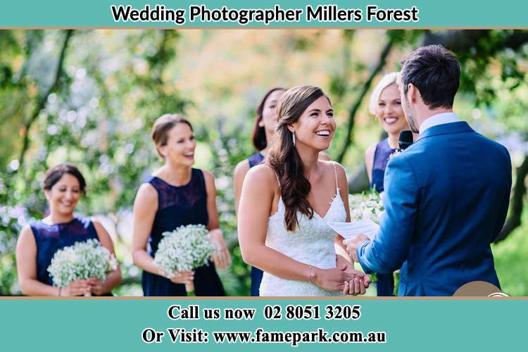 The Groom is reading a note for her happy Bride as she looks at him Millers Forest