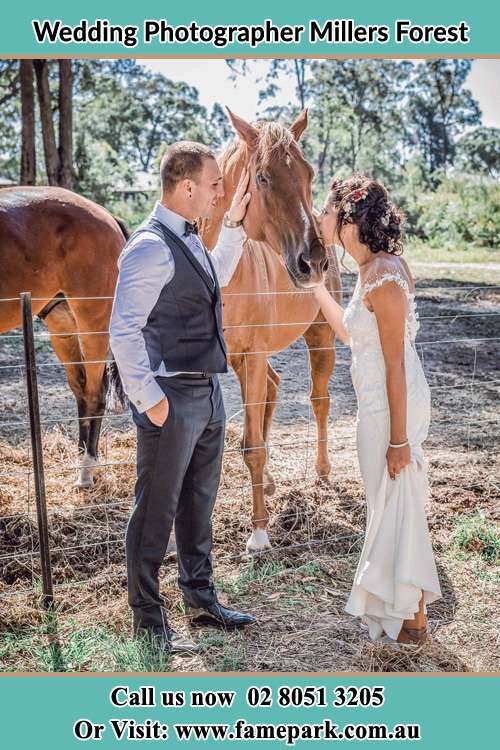 Photo of the Groom holding the horse and the Bride kiss the horse Millers Forest NSW 2324