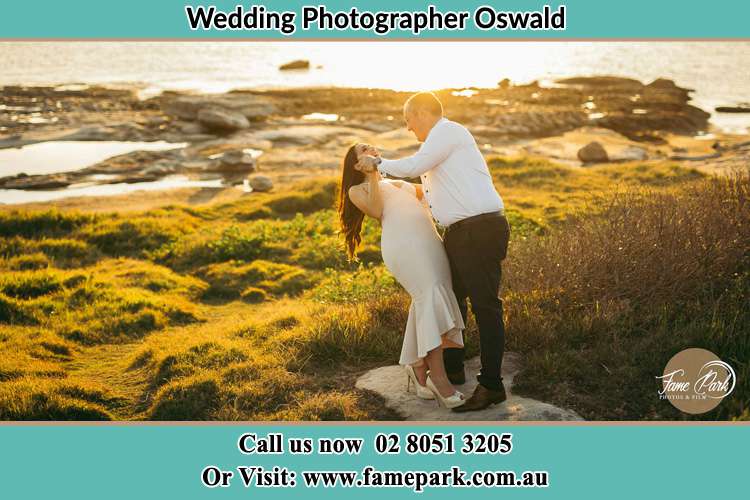 Photo of the Bride and the Groom dancing with a romantic lake background Oswald NSW 2321