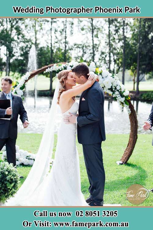 Photo of the Bride and the Groom kiss at the wedding ceremony Phoenix Park