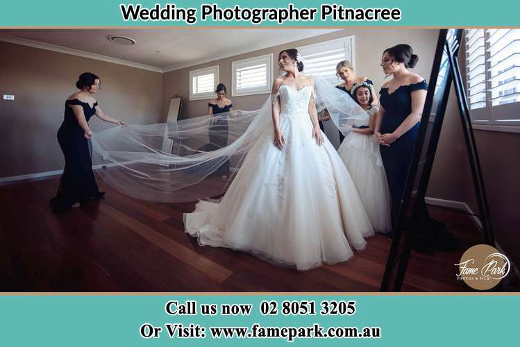 Photo of the Bride checking her wedding gown by her bridesmaids and flower girl Pitnacree NSW 2323