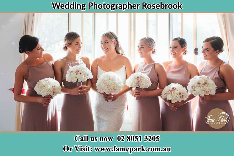 Photo of the Bride and her bridesmaids each holding a bouquet of flowers Rosebrook