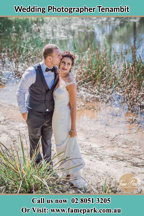 Photo of the Groom kiss his Bride near the lake Tenambit NSW 2323